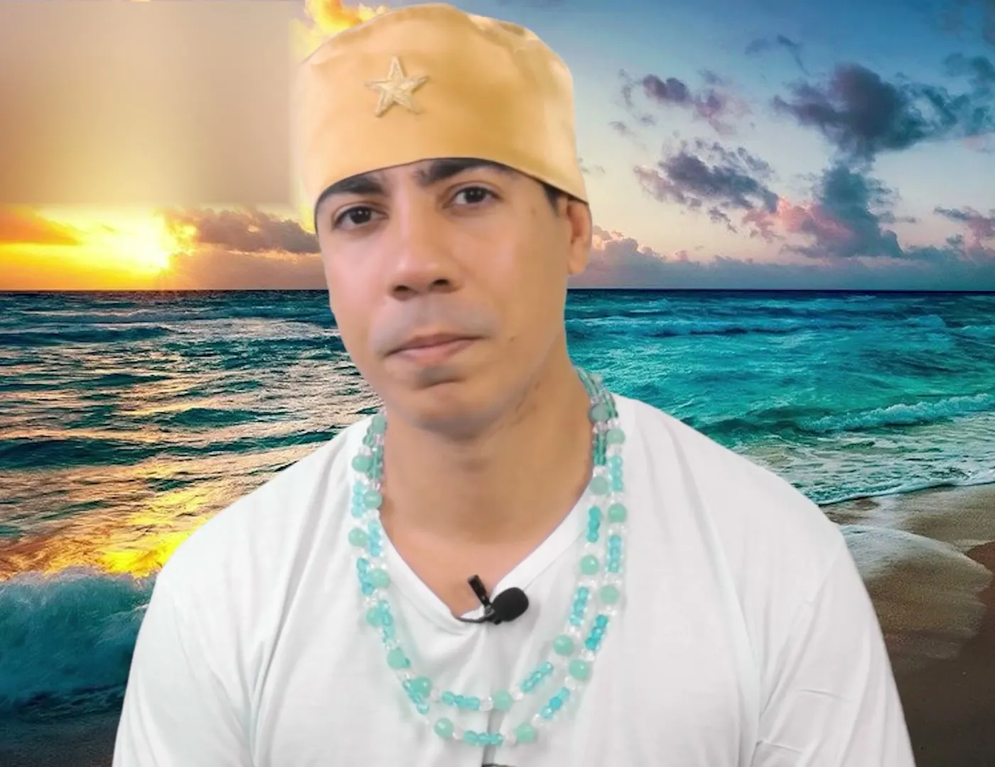Bruno Amorim, de camiseta branca e guias azul-claras, diante do mar ao pôr do sol